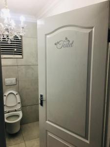 een badkamer met een toilet en een deur met het woord opgesloten bij Maso palace in Polokwane