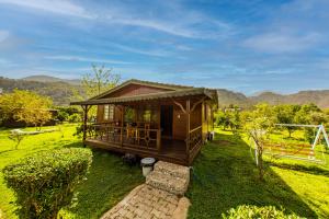 una pequeña cabaña en un campo con montañas en el fondo en Ikiz Villas, en Cıralı