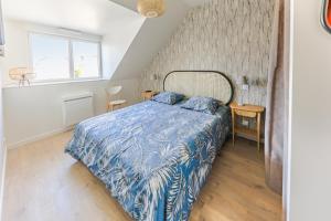 Schlafzimmer mit einem Bett mit blauer Decke in der Unterkunft Cap Ouest in Concarneau