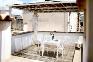 a white table and chairs on a balcony at Le Viùzze Apartment in Tricase +7 photos