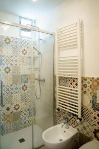 a bathroom with a glass shower and a sink at Le Viùzze Apartment in Tricase
