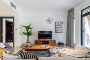 a living room with a table and a tv at The Smart Concierge - Reehan 2 in Dubai