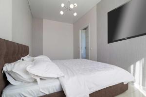 a bedroom with a bed and a flat screen tv at Lux Most City Area, Panoramic city View in Dnipro