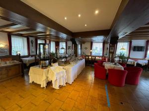 a restaurant with white tables and red chairs at Hotel Württemberger Hof Garni in Rottenburg