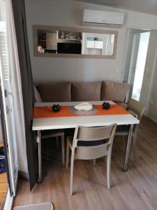 a dining room and kitchen with a table and chairs at Mobile Home Mali raj in Biograd na Moru