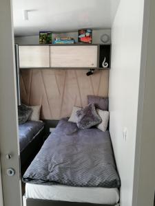 a small bedroom with a bed and a couch at Mobile Home Mali raj in Biograd na Moru