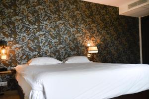 a bedroom with a large bed with a floral wallpaper at Hôtel Les Muses in Annecy