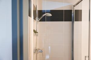 a bathroom with a shower with a glass door at Hôtel Les Muses in Annecy
