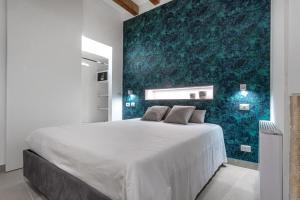 a bedroom with a large bed with a green wall at Casa Zummo Ortigia Luxury Apartment in Siracusa