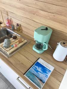 een aanrecht met een koffiezetapparaat en een tijdschrift bij « L’Olympe » - à 300 M de la plage in Courseulles-sur-Mer