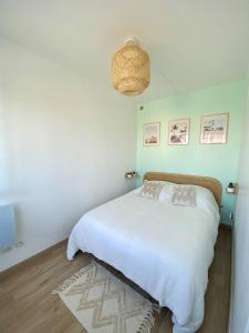 een slaapkamer met een groot wit bed en een tapijt bij « L’Olympe » - à 300 M de la plage in Courseulles-sur-Mer