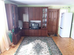 - une cuisine avec des placards en bois et un réfrigérateur blanc dans l'établissement Ципель 1, à Szack