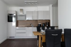 a kitchen with white cabinets and a wooden table at Villa Insel in Börgerende-Rethwisch +4 photos