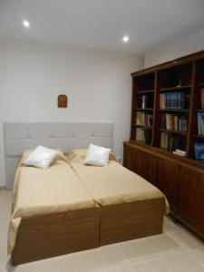 1 dormitorio con cama y estante para libros en Elena's old Corfu town apartment, en Corfú