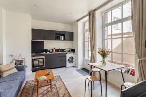 a living room with a couch and a table at Les Carmélites - Appartements dans l'hyper-centre de Rennes in Rennes