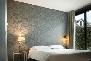 a bedroom with a large bed and a wall at Hôtel Les Muses in Annecy