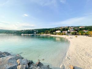 Blick auf einen Strand mit Menschen im Wasser in der Unterkunft Apartman Marija in Jadranovo
