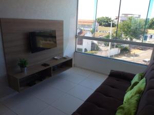 ein Wohnzimmer mit Couch und Flachbildfernseher in der Unterkunft Apartamentos Brisa del Mar in Luis Correia