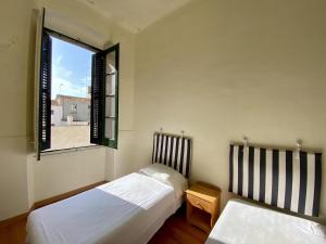 two beds in a room with a window at El masnou in Masnou