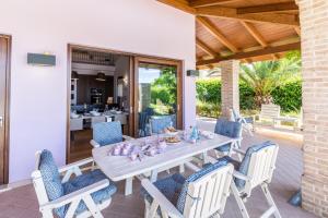 Une table à manger et des chaises sont disponibles sur la terrasse. dans l'établissement Villa Sara, à San Costanzo