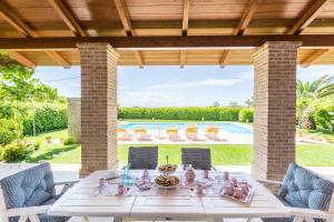 une terrasse avec une table, des chaises et une piscine dans l'établissement Villa Sara, à San Costanzo