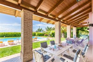 San CostanzoにあるVilla Saraのテーブルと椅子とプールのあるパティオ