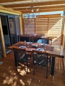 einen Holztisch und Stühle auf einer Terrasse in der Unterkunft Mobile Home Mali raj in Biograd na Moru