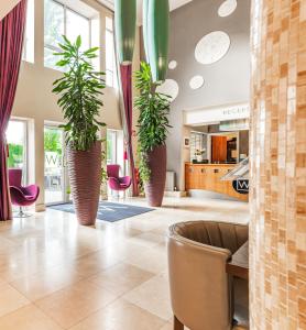 a lobby with three potted plants in a building at Wilton Hotel Bray in Bray