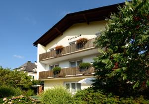 a building with potted plants on a balcony at Appartements Kanauf in Krumpendorf am Wörthersee