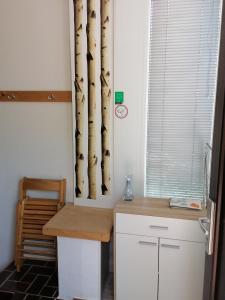 eine Küche mit einem Schreibtisch und einem Fenster mit Bambusvorhängen in der Unterkunft Peter rooms in Ljubljana