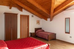 sypialnia z 2 łóżkami i drewnianym sufitem w obiekcie B&B La Mortella w mieście Albanella