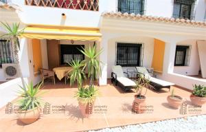 un patio al aire libre con macetas en un edificio en Pueblo Del Parque 3 - Terraza soleada con jardín - Piscina y Playa - Urbanización tranquila, en Benalmádena