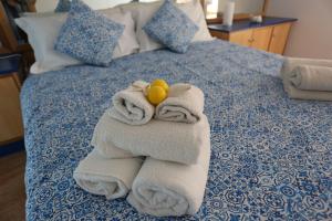 uma pilha de toalhas e um bicho de peluche numa cama em Casa Gilda em Sorrento