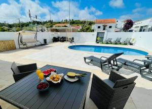 a patio with a table and chairs and a pool at Soares Village II in Amoreira