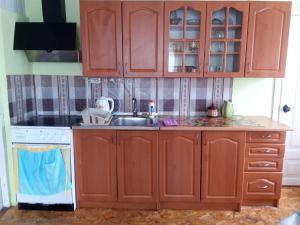 een keuken met houten kasten en een wastafel bij Ципель 1 in Szack