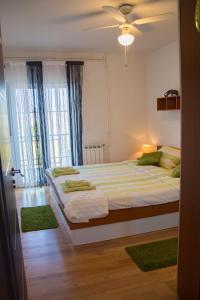 a bedroom with a large bed with green rugs at Apartment Dino in Selce