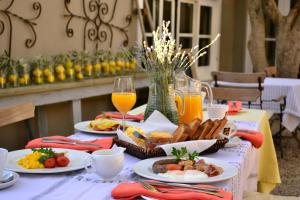 einen Tisch mit Teller mit Speisen und Orangensaft in der Unterkunft Cafe Felix & Old Oak Manor in Riebeek-Kasteel