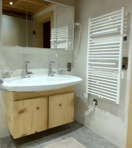 ein Bad mit einem Waschbecken und einem Spiegel in der Unterkunft Ferienwohnung Senftahaus in Innervillgraten