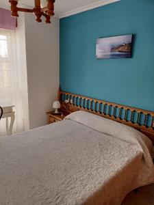 1 dormitorio con 1 cama con pared azul en Choyo 2, en Ferrol