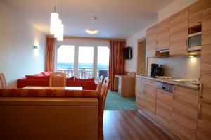 a living room with a red couch and a kitchen at Villa Buchenhain in Ehrwald