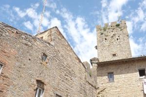 a large brick building with a tower on top of it at Matteotti Loft in Volterra