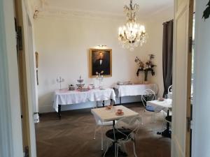 une salle à manger avec deux tables et un lustre dans l'établissement VILLA HENRI, à Flavy-le-Martel