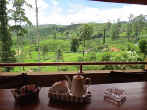 a tea kettle on a table with a view of a field at Tea Hills Bungalow in Hatton