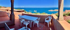 a table and chairs on a balcony overlooking the ocean at Appartamento vista mare Maya 2 in Costa Paradiso