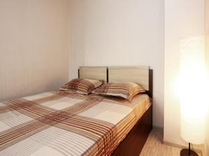 モスクワにあるApartLux Sokolのベッドルーム1室(ストライプのシーツと枕が備わるベッド1台付)