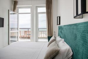 a bedroom with a bed and a large window at Villa delle Palme in Santa Marinella
