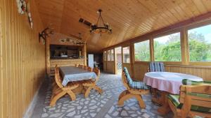 a screened in porch with a table and chairs at La Mosu-n Retezat in Nucşoara