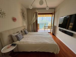 una camera con un grande letto e un balcone di appartamento con bellissima vista a Campione dʼItalia