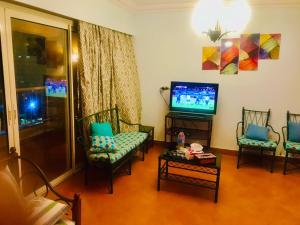 a living room with three chairs and a television at العين السخنة بورتو الاهرامات عائلات فقط in Ain Sokhna