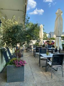 an outdoor patio with tables and chairs and umbrellas at Pension Schmidt in Podersdorf am See